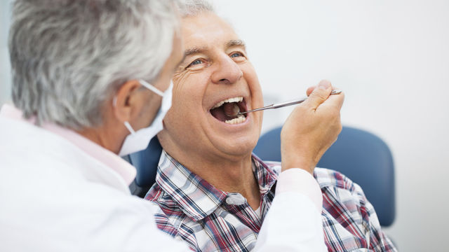 Médico revisando la boca de un paciente