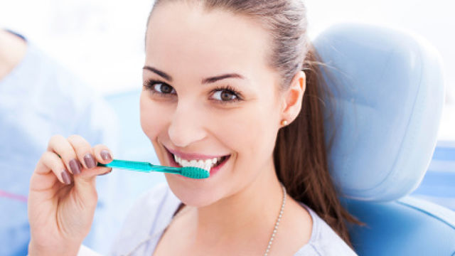 Mujer sonriente cepillandose los dientes