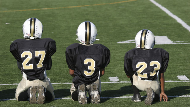 Tres jugadores de futbol americano en una cancha