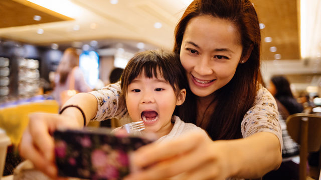 Madre e hija jugando con el teléfono