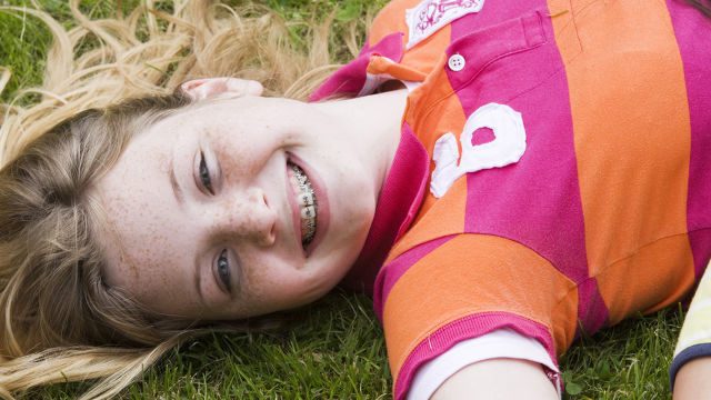 Chica sonriendo con tratamiento de ortodoncia