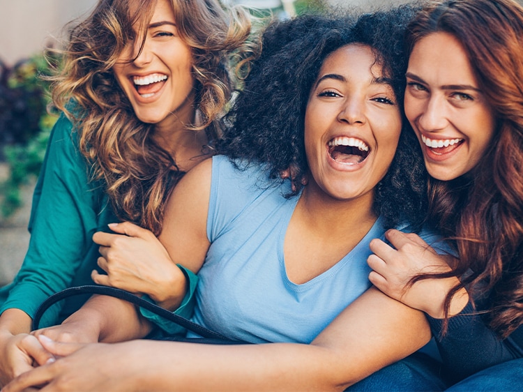 three women smiling after using colgate