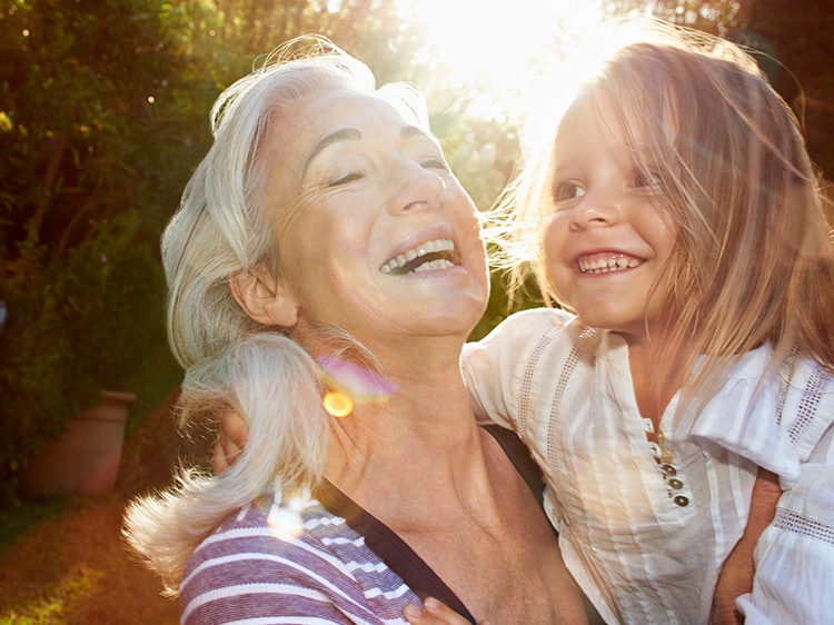 smiling woman holding smiling toddler