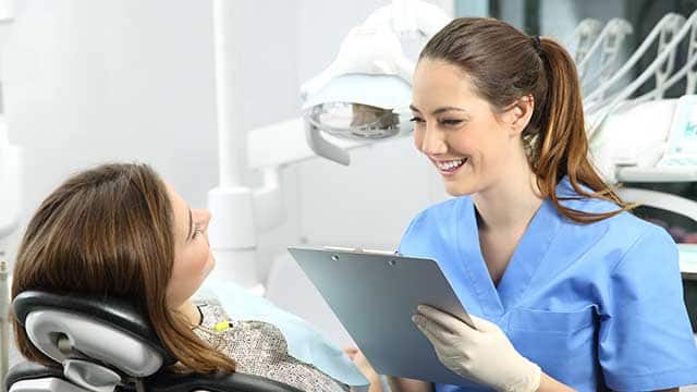 Dentista con preguntando a un paciente