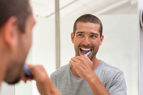 Hombre cepillándose los dientes.
