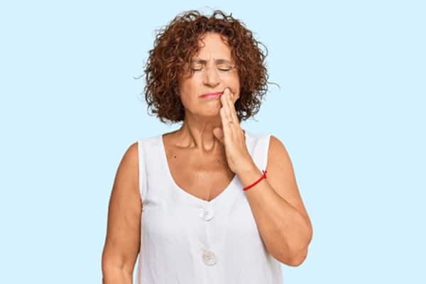 Mujer con dolor en las encías Mujer con dolor en las encías
